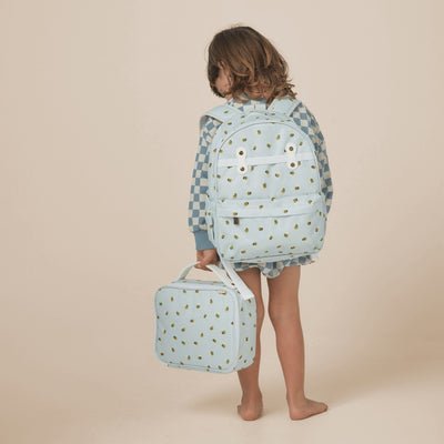 Child wearing a pale blue bee print backpack and carrying a matching wheeled suitcase, shown from behind in a studio setting by Olli Ella Kids