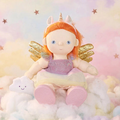 Unicorn Nova doll with bright ginger hair, a unicorn horn, golden wings, and a pink outfit sitting among fluffy clouds from Dinkum Dolls