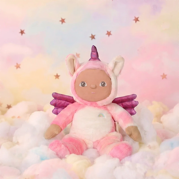 Plush toy in a unicorn costume sitting on fluffy clouds with a pastel starry background