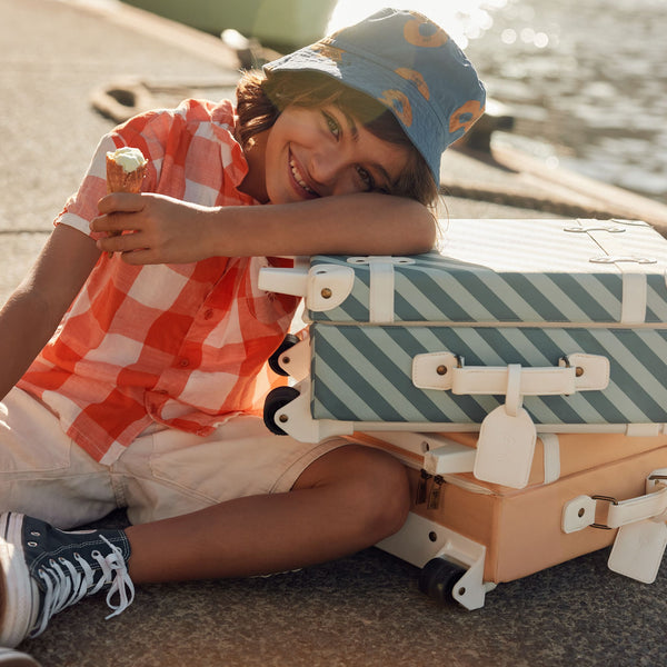 Stylish kids travel suitcase in blue striped design. Perfect for kids' travel, featuring a durable, lightweight build and eco-friendly materials. Made from recycled plastic bottles.