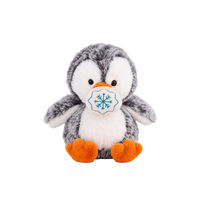 Fluffy plush penguin with grey speckled fur, a white face and tummy, black eyes, and an orange beak and feet, sitting beside a small cream fabric snowball embroidered with a blue snowflake.