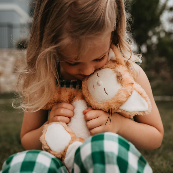 Little girl play with ginger tabby cat, soft plush toy doll for kids