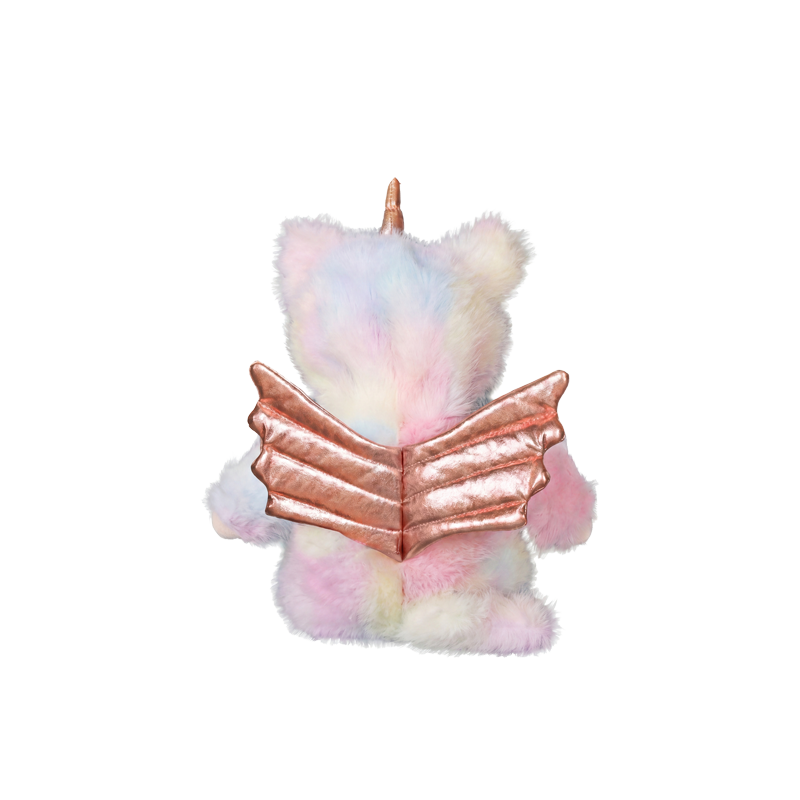 Pastel rainbow unicorn plush doll with a rose gold horn holding an open rose gold book, shown from behind, from Cozy Day Dinkums