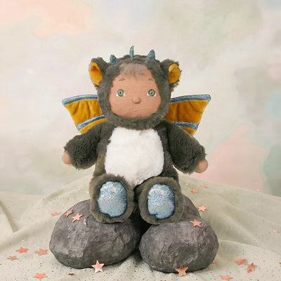Stuffed toy dragon with a soft texture sitting on a stone