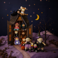 Dinkum Dolls by Olli Ella dolls in a spooky Holiday Hollow scene, featuring a doll wearing a black witch dress and pointed hat beside a dollhouse under a starry moonlit sky