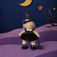 Dinkum Dolls by Olli Ella doll dressed as a witch in a black glittery dress and pointed hat with a broom in a purple and navy Halloween scene