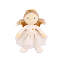 Plush doll dressed as an angel, with fluffy light-brown hair in pigtails, embroidered blue eyes, a gold velvet halo and wings, a cream velvet top with a small rainbow patch, a cream tulle skirt with gold glitter dots, and cream booties.