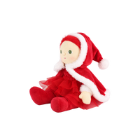 Plush doll with red hair, embroidered green eyes and rosy cheeks, wearing a red velvet hooded cape with white fluffy trim over a red outfit with a tulle skirt, white fluffy cuffs and a small rainbow patch on the chest.