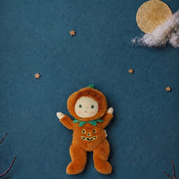Jules Jack o Lantern plush doll in an orange pumpkin costume with a smiling face, surrounded by stars and a moon on a blue background by Dinkum Dolls by Olli Ella
