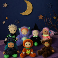 Jules Jack o Lantern Dinky Dinkum doll in an orange pumpkin outfit surrounded by Halloween themed dolls beneath a crescent moon from Dinkum Dolls by Olli Ella