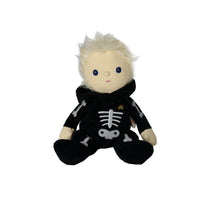 Dinky Dinkum Scully Skeleton plush doll with soft blonde hair and a black skeleton outfit, seated and smiling, from Dinkum Dolls by Olli Ella