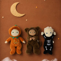 Dinky Dinkum Scully Skeleton doll in a black skeleton costume with pumpkin and bear dolls beneath a crescent moon from Dinkum Dolls by Olli Ella