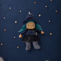 Winnie Witch Dinky Dinkum doll with green hair, pointed witch hat, starry black dress, striped stockings, and outstretched arms on a navy starry background by Dinkum Dolls by Olli Ella