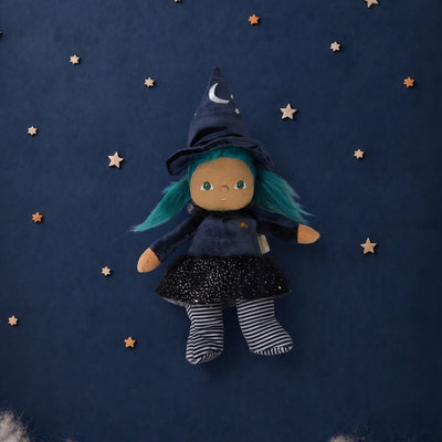 Winnie Witch Dinky Dinkum doll with green hair, pointed witch hat, starry black dress, striped stockings, and outstretched arms on a navy starry background by Dinkum Dolls by Olli Ella
