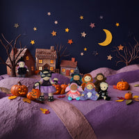 Dinkum Dolls by Olli Ella Dream Dinkum dolls in Halloween costumes gather with pumpkins and a lollipop beneath a crescent moon in a spooky village scene
