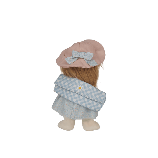 Stuffed toy with a pink hat and light blue dress on a black background
