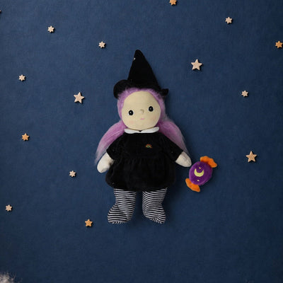 Willa witch doll with pink hair black hat and dress striped leggings and a purple candy accessory on a starry blue background by Dinkum Dolls by Olli Ella