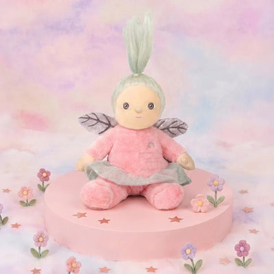 Plush fairy toy with pink outfit and green hair on a pastel background