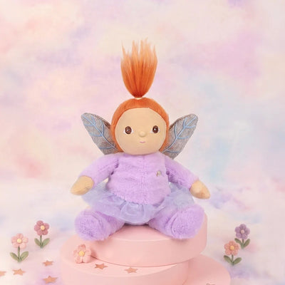 Plush fairy toy with red hair and wings on a pastel background