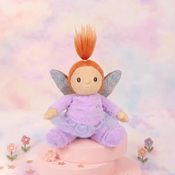 Plush fairy toy with red hair and wings on a pastel background