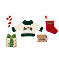 Christmas doll accessory set: a cream knit jumper with green trim and an embroidered rainbow and holly design, a red plush stocking with white fluffy cuff, a red and white striped plush candy cane, a holly-print gift box with a green velvet bow, and a felt “To Santa, The North Pole” letter.
