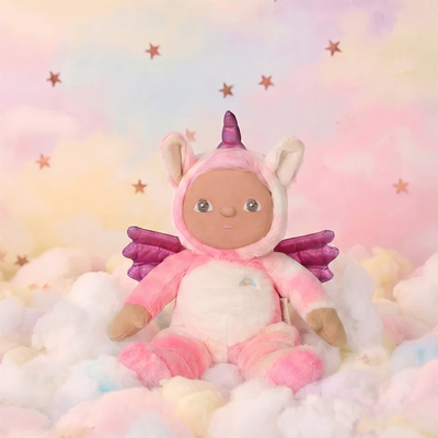 Plush toy in a unicorn costume sitting on fluffy clouds with a pastel starry background