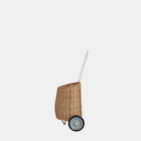 Natural rattan wheeled basket with a white pull handle and two black wheels, designed for children to carry toys and treasured belongings