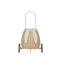 Olli Ella Kids Rattan bunny luggy basket with floral Pansy lining, floppy bunny ears, rounded woven body, handle, and two wheels for children’s play and storage