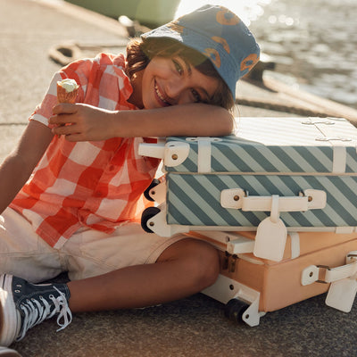 Stylish kids travel suitcase in blue striped design. Perfect for kids' travel, featuring a durable, lightweight build and eco-friendly materials. Made from recycled plastic bottles.